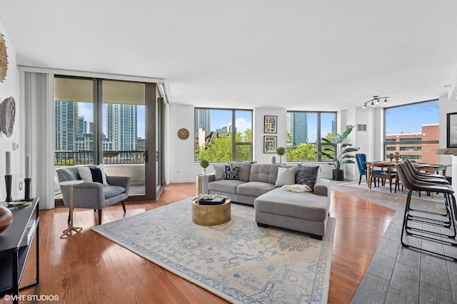 living area with wood finished floors, floor to ceiling windows, and a city view