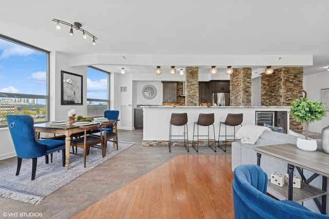 dining space featuring light wood finished floors and beverage cooler