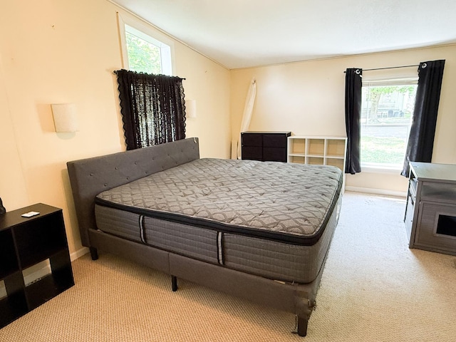 carpeted bedroom featuring lofted ceiling and baseboards