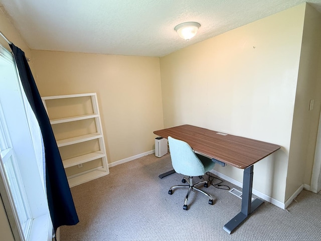 carpeted home office featuring baseboards and a textured ceiling