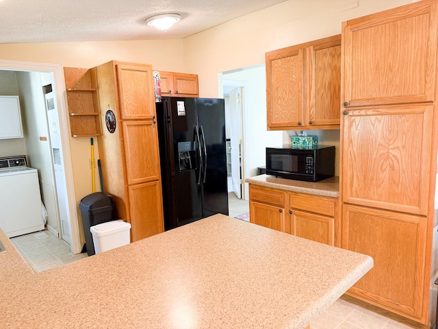 kitchen featuring black appliances, washer / clothes dryer, and light countertops