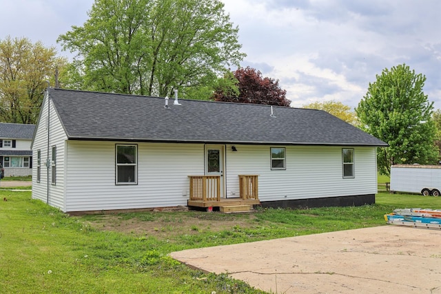 211 N Center St, Buda, IL 61314 - rear view of house with a shingled roof and a lawn