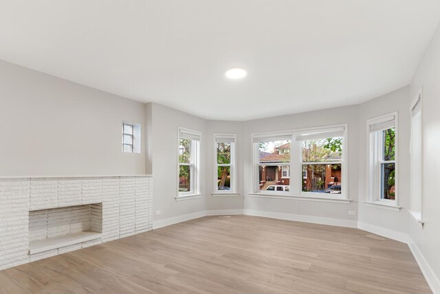 unfurnished living room with light wood-type flooring, baseboards, healthy amount of natural light, and recessed lighting