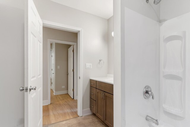 bathroom featuring vanity, bathtub / shower combination, and baseboards