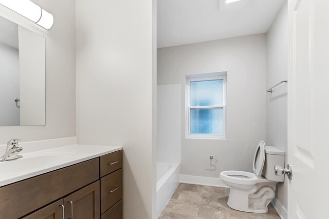 full bath with toilet, vanity, and baseboards
