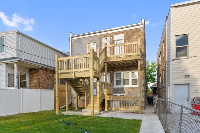 rear view of house featuring brick siding, stairway, and a deck