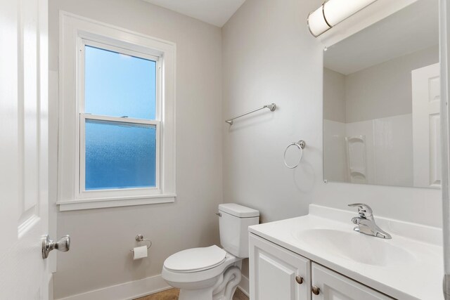 full bath featuring toilet, vanity, baseboards, and a shower