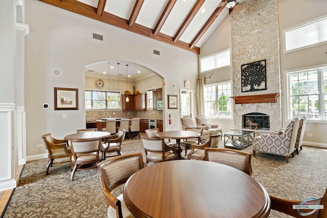 1265 Everwood Ln, Aurora, IL 60505 - dining area featuring high vaulted ceiling, a stone fireplace, arched walkways, beamed ceiling, and recessed lighting