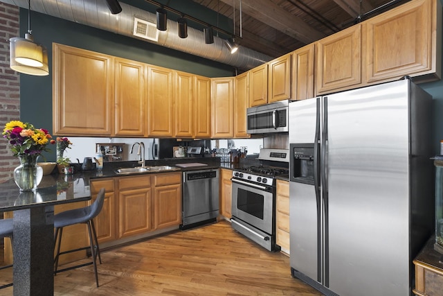 2735 W Armitage Ave Unit 309, Chicago, IL 60647 - kitchen featuring a sink, stainless steel appliances, visible vents, dark countertops, and light wood-style floors