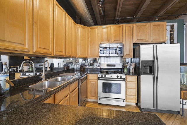 2735 W Armitage Ave Unit 309, Chicago, IL 60647 - kitchen featuring light wood finished floors, a sink, dark stone counters, beamed ceiling, and appliances with stainless steel finishes