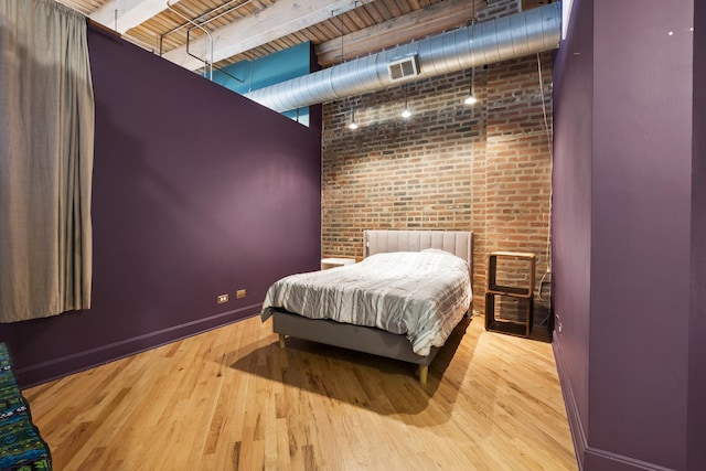 2735 W Armitage Ave Unit 309, Chicago, IL 60647 - bedroom featuring brick wall, a high ceiling, visible vents, and wood finished floors