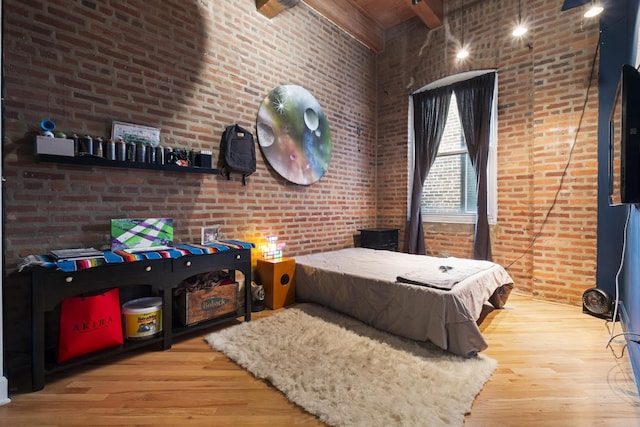 2735 W Armitage Ave Unit 309, Chicago, IL 60647 - bedroom with brick wall, beam ceiling, a towering ceiling, and wood finished floors