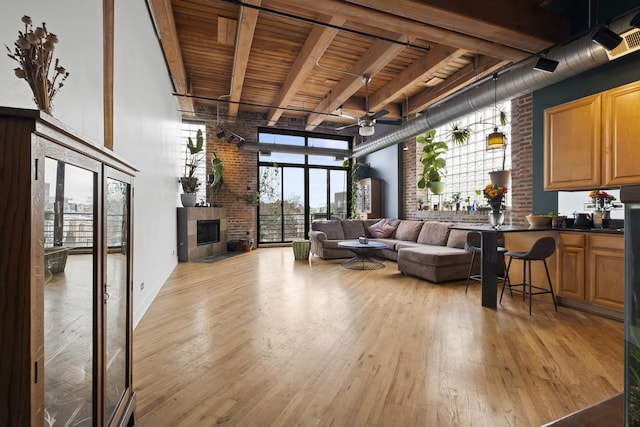 2735 W Armitage Ave Unit 309, Chicago, IL 60647 - living room featuring ceiling fan, light wood finished floors, brick wall, wood ceiling, and a high ceiling