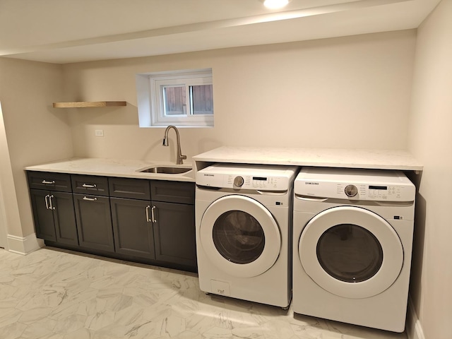 washroom with a sink, cabinet space, marble finish floor, and washer and dryer