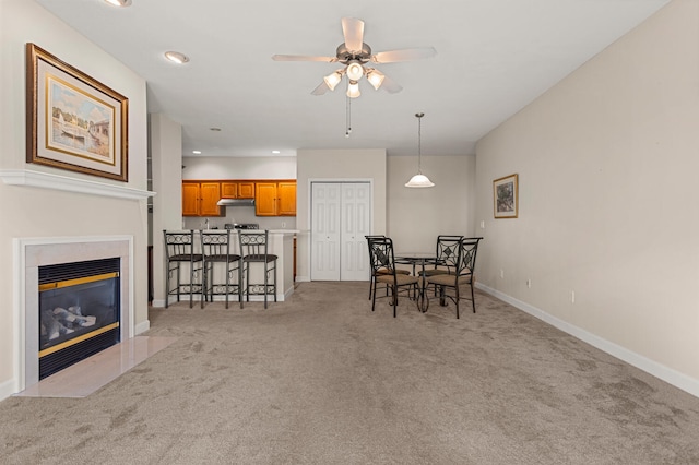 dining area with light carpet, baseboards, a ceiling fan, recessed lighting, and a fireplace with flush hearth