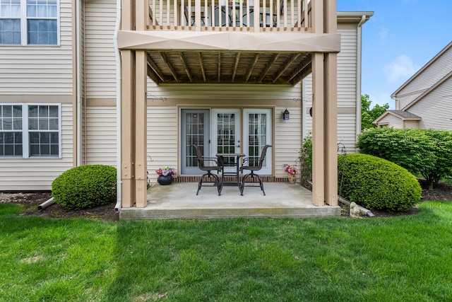 doorway to property with a lawn, a balcony, and a patio