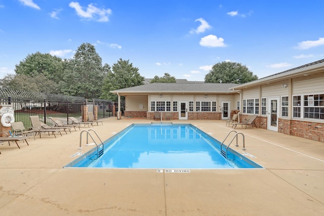 community pool featuring a patio and fence