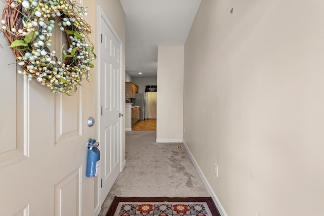 hallway with light carpet and baseboards