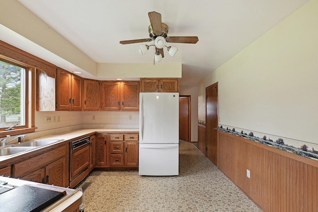 200 W Eisenhower St, Waterman, IL 60556 - kitchen featuring freestanding refrigerator, paneled dishwasher, brown cabinetry, and ceiling fan