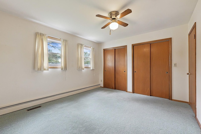 200 W Eisenhower St, Waterman, IL 60556 - unfurnished bedroom featuring multiple closets, light colored carpet, ceiling fan, and baseboard heating