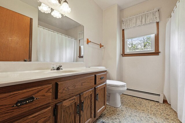 200 W Eisenhower St, Waterman, IL 60556 - bathroom featuring a baseboard radiator, toilet, and vanity