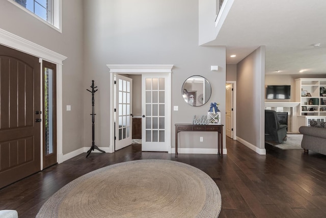 9760 Janel Dr, Bloomington, IL 61705 - foyer featuring a towering ceiling, dark wood finished floors, french doors, baseboards, and a fireplace