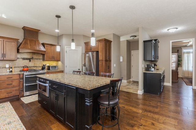 9760 Janel Dr, Bloomington, IL 61705 - kitchen with stainless steel appliances, custom exhaust hood, dark wood-type flooring, and backsplash