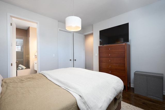 bedroom featuring dark wood-style floors and ensuite bath