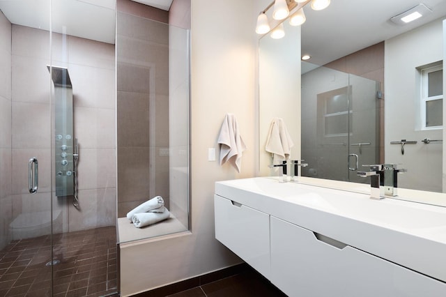 full bathroom featuring a stall shower, double vanity, tile patterned floors, and recessed lighting