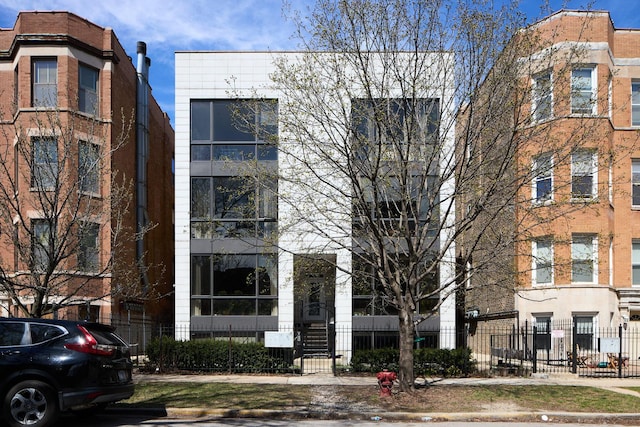 view of apartment building / complex featuring a fenced front yard