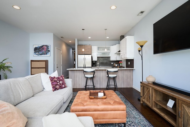 living area featuring dark wood finished floors and recessed lighting
