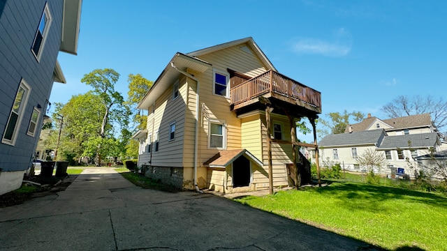 view of home's exterior featuring a lawn, a residential view, and a balcony