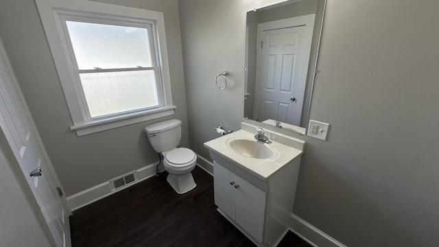 bathroom featuring toilet, baseboards, vanity, and wood finished floors