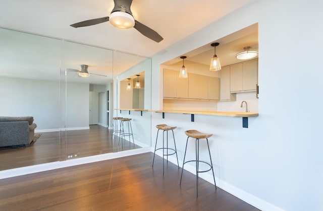 1560 N Sandburg Ter Unit 2506J, Chicago, IL 60610 - kitchen featuring a ceiling fan, baseboards, a kitchen breakfast bar, and wood finished floors