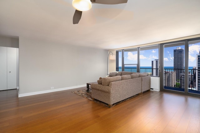 1560 N Sandburg Ter Unit 2506J, Chicago, IL 60610 - living room featuring wood finished floors, ceiling fan, plenty of natural light, baseboards, and a wall of windows