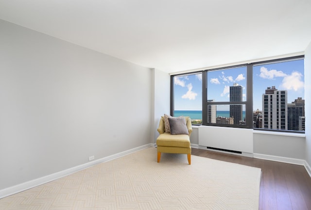1560 N Sandburg Ter Unit 2506J, Chicago, IL 60610 - sitting room with wood finished floors, baseboards, radiator, a city view, and a water view