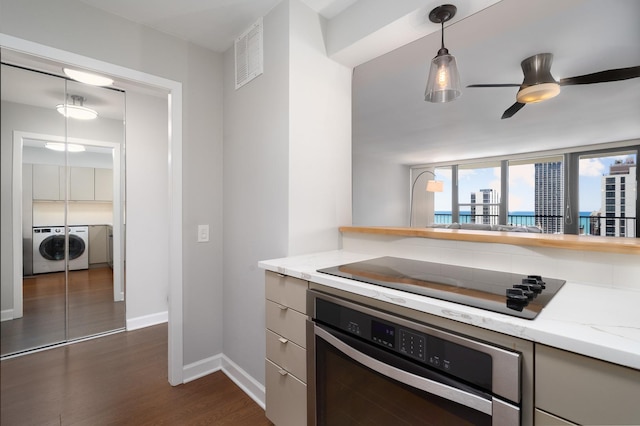 1560 N Sandburg Ter Unit 2506J, Chicago, IL 60610 - kitchen with oven, washer and clothes dryer, black electric stovetop, dark wood-style floors, and baseboards