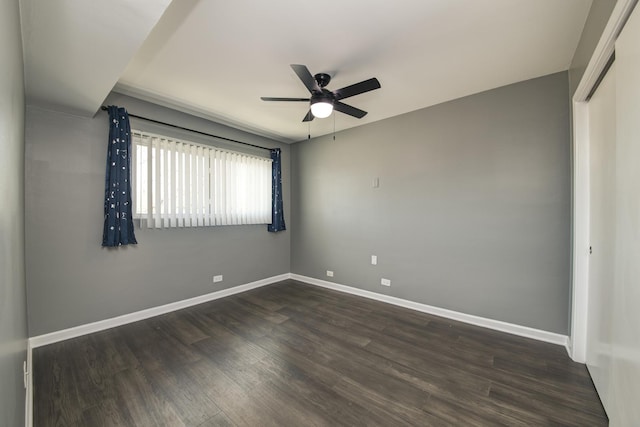 unfurnished bedroom featuring baseboards, dark wood-type flooring, a closet, and a ceiling fan