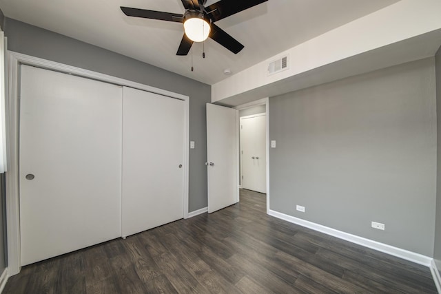 unfurnished bedroom with wood finished floors, a closet, baseboards, and ceiling fan