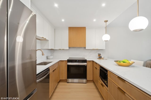 1560 N Sandburg Ter Unit 411J, Chicago, IL 60610 - kitchen with stainless steel appliances, a sink, light wood-type flooring, exhaust hood, and white cabinetry