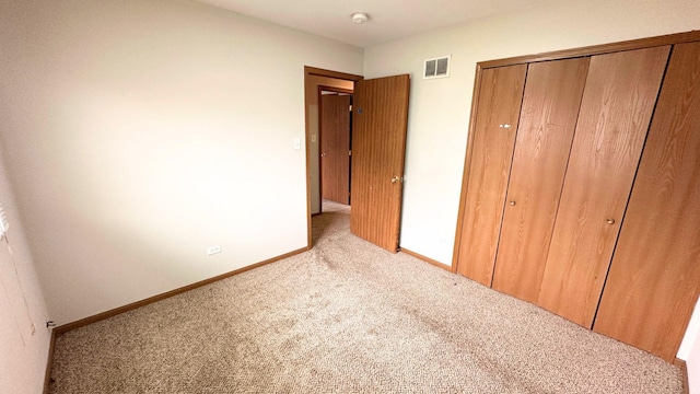 unfurnished bedroom featuring carpet, a closet, and baseboards