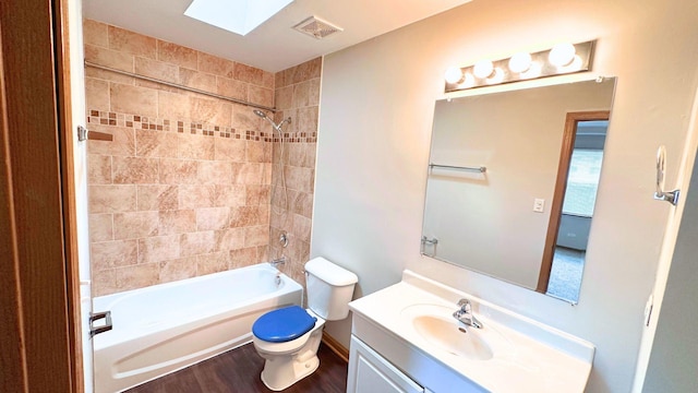 full bathroom with a skylight, toilet, shower / bath combination, vanity, and wood finished floors