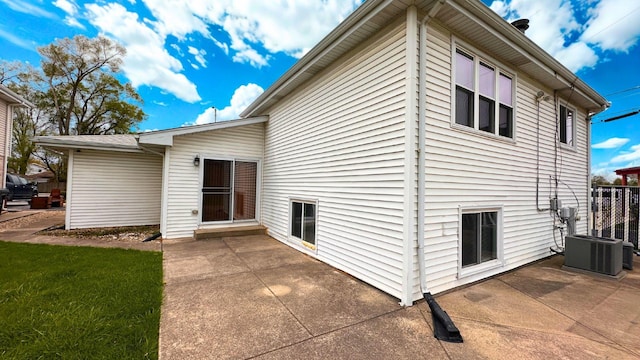 rear view of property with cooling unit and a patio