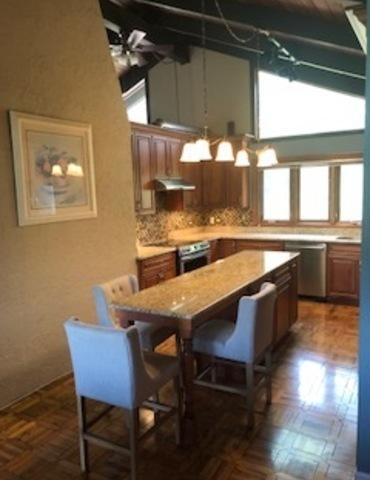 23105 N High Ridge Rd, Barrington, IL 60010 - kitchen with appliances with stainless steel finishes, a kitchen island, light countertops, and a kitchen breakfast bar