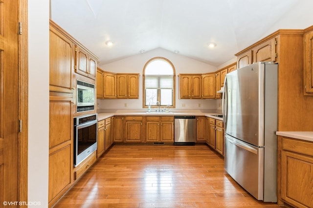 296 Regina Ln, Belvidere, IL 61008 - kitchen with appliances with stainless steel finishes, vaulted ceiling, a sink, light wood-type flooring, and light countertops
