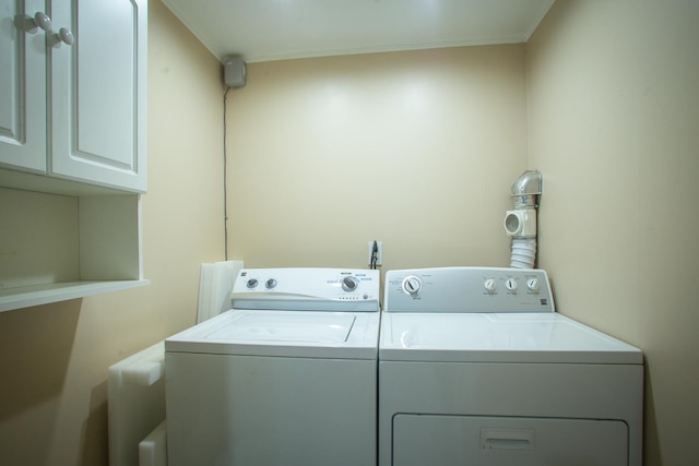 washroom with washing machine and clothes dryer and cabinet space