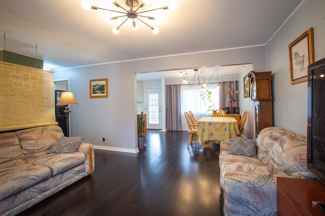 living room with a chandelier, wood finished floors, baseboards, and ornamental molding