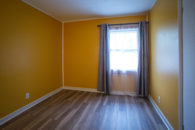 empty room with dark wood-style floors and baseboards