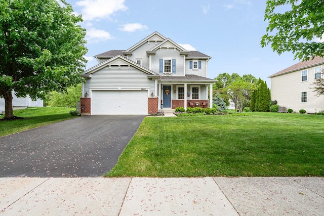 24210 Apple Creek Ln, Plainfield, IL 60586 - view of front of house featuring asphalt driveway, brick siding, covered porch, a front yard, and an attached garage