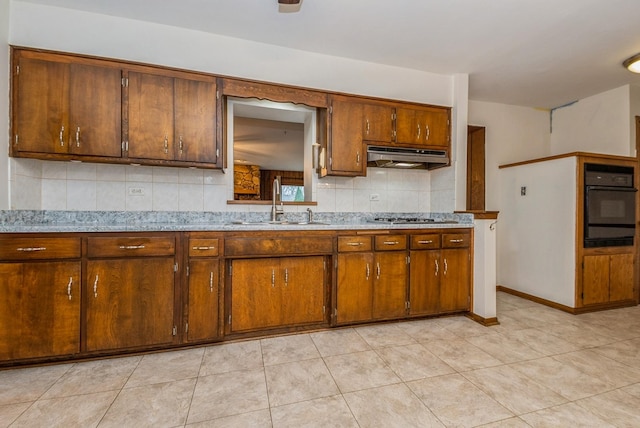 10756 Mason Ave, Chicago Ridge, IL 60415 - kitchen with a sink, black oven, under cabinet range hood, light countertops, and decorative backsplash